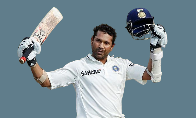 Richest Cricketers: Sachin Tendulkar Celebrating a Milestone - Image of Sachin Tendulkar, the richest cricketer, in his white cricket uniform, raising both hands in celebration. He holds a bat in one hand and a helmet in the other, wearing cricket gloves, against a simple grey background.