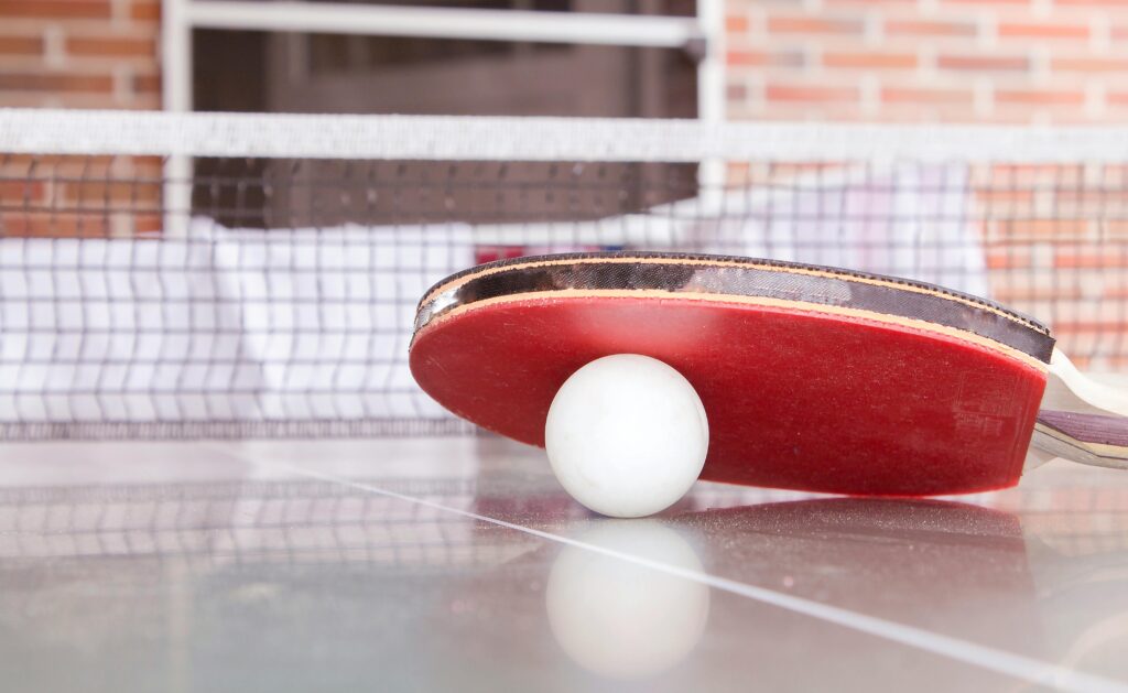 Table Tennis Balls: Close-Up of White Ball and Red Paddle